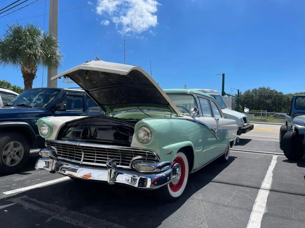 Classic teal car with its hood open outside Jupiter Car-Care