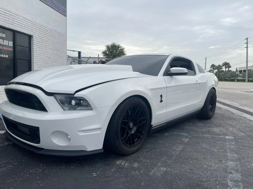 White Mustang parked outside Jupiter Car-Care in Jupiter
