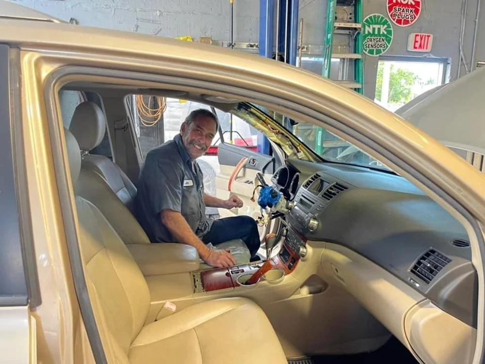 Technician working inside a vehicle at Jupiter Car-Care